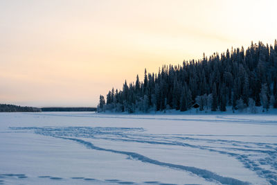 Scenic view of snow covered field against sky during sunset