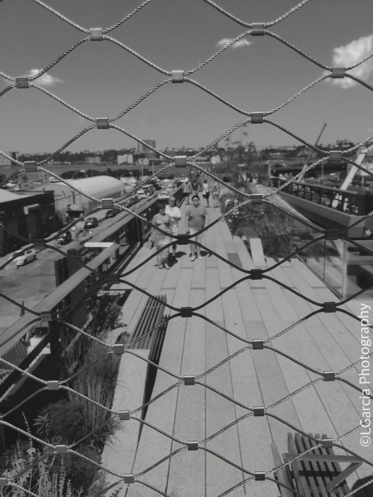 building exterior, architecture, built structure, city, chainlink fence, fence, sky, metal, protection, day, high angle view, outdoors, no people, safety, transportation, cityscape, development, construction site, mode of transport, sunlight