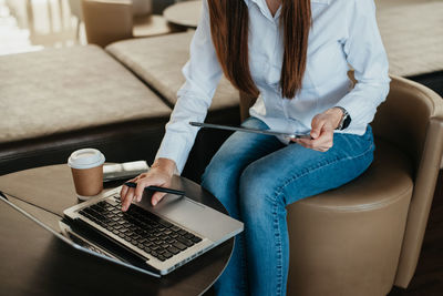 Midsection of woman using laptop