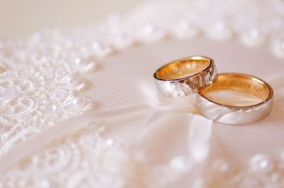 Close-up of wedding rings on cushion