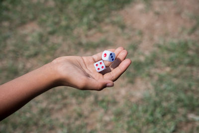 Cropped hand of person holding dice