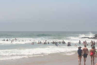 People at beach against sky