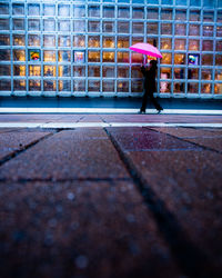 Side view of a woman walking on wet street