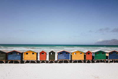 Beach umbrellas by sea against sky