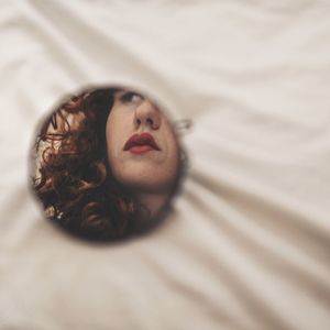 Portrait of young woman lying on bed