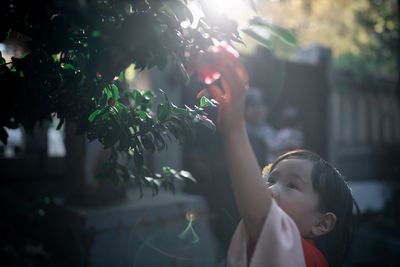 Portrait of a girl looking through tree