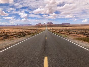 Empty road against sky and clouds, monument valley view from forrest gump point