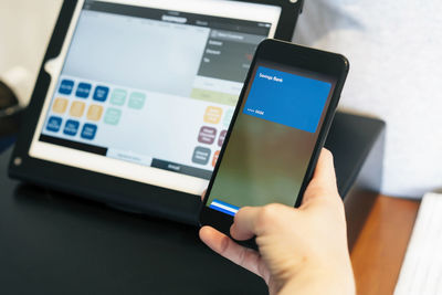 Cropped hand of customer making mobile payment at store