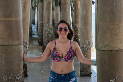 Woman standing below pier at beach