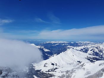 Scenic view of snowcapped mountains against blue sky