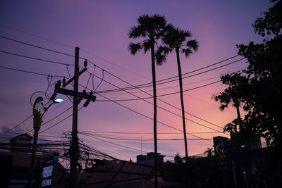 Low angle view of silhouette electricity pylon against sky