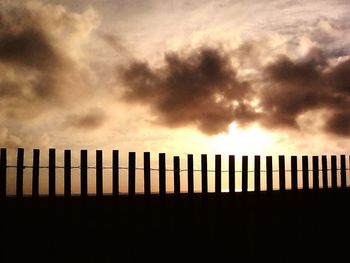 Silhouette of building against cloudy sky