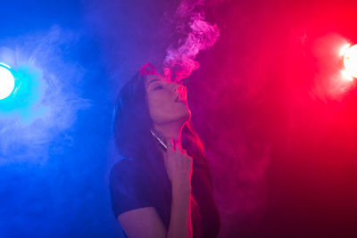 Full length of young woman in illuminated red light