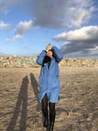 Smiling woman walking on land against sky