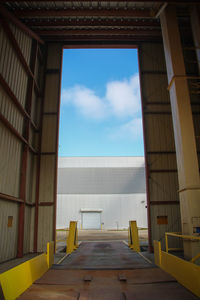 Warehouse against sky seen from large doorway of factory