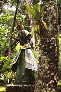 Statue against trees in forest