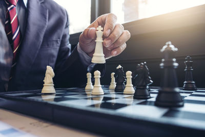 Midsection of businessman playing chess