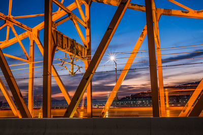 Low angle view of illuminated bridge against sky during sunset
