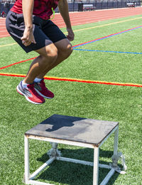 Low section of man playing soccer on field