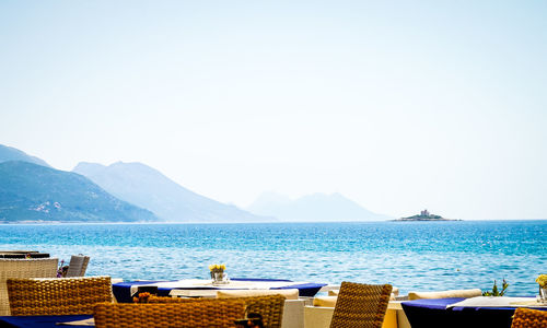 Scenic view of sea and mountains against clear sky