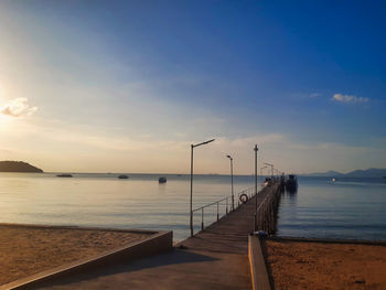Pier over sea against sky during sunset