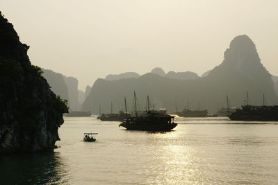 Boats in sea against clear sky