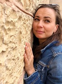 Close-up of woman leaning on wall