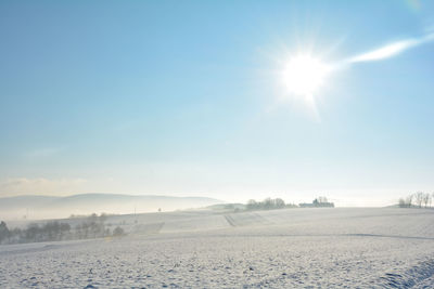 Fog over a snowy landscape on an early morning with sun and copy space