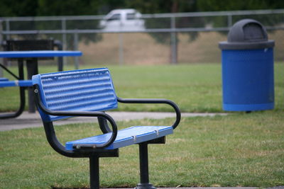 Empty blue bench on field in park