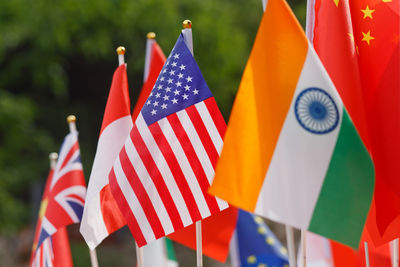Various national flags against trees