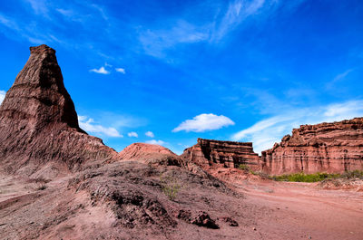 Rock formations on mountain against cloudy sky