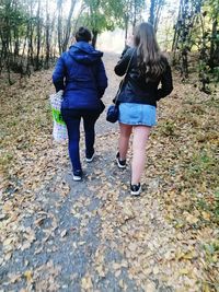 Rear view of women walking on footpath