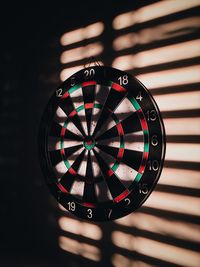 Dartboard on wall with shadow at home