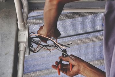 Close-up of man cutting wire at home