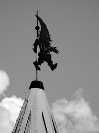 Low angle view of weather vane against sky