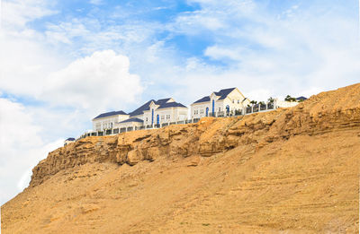 Low angle view of buildings against cloudy sky