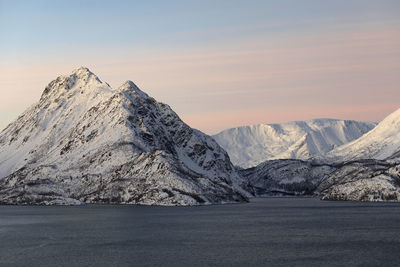 Scenic view of snowcapped mountains against sky during sunset