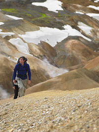 Couple hiking up steep slope in the icelandic highlands