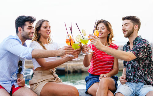 Friends toasting with drinks outdoors