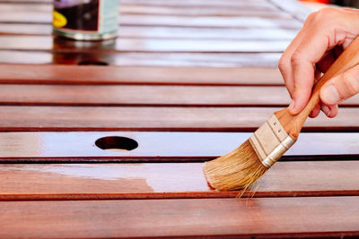 Cropped hand of woman holding wooden table