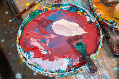 Bright colors in the artist's palette and a brush in an art workshop