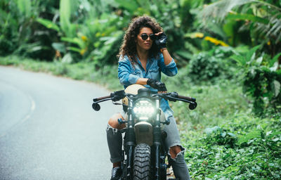 Young woman riding motorcycle on road