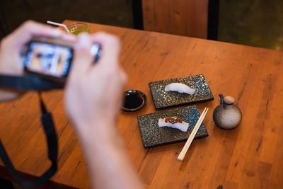 Men are taking photos. japanese cuisine menu set on wooden table