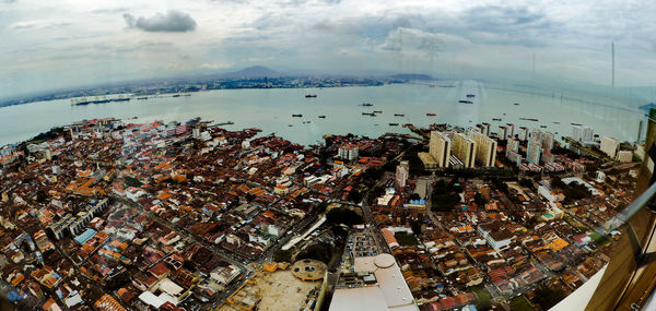 High angle view of cityscape by sea against sky