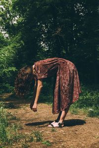 Full length of woman standing on field against trees