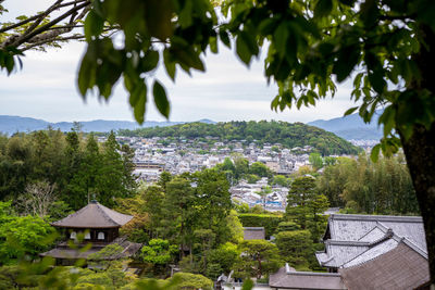 Houses by trees and mountains against sky