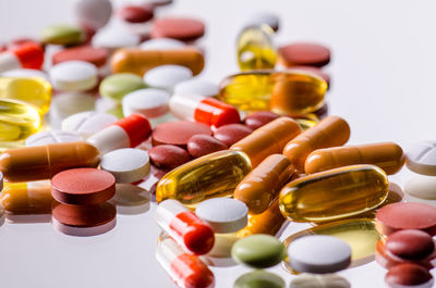 Close-up of multi colored bottles on white background