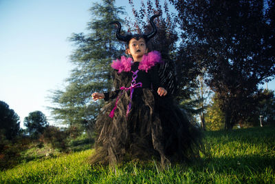 Girl with maleficent costume playing in the woods