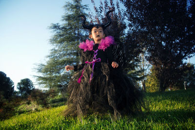 Portrait of woman standing on grassy field