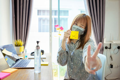 Woman holding mobile phone at home